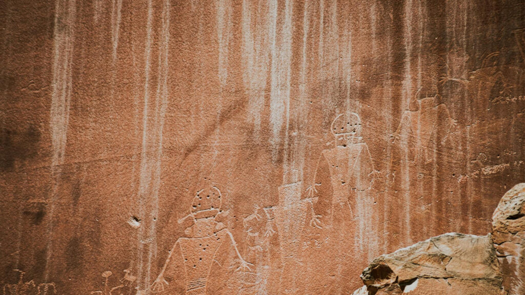 Ancient cave paintings depicting people and animals, warm earthy tones, prehistoric style