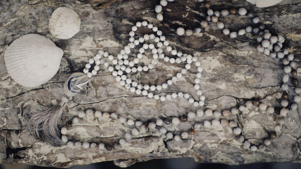 Ancient necklace made of shells or beads, laid on a rustic surface.